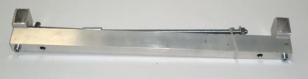 Aluminiumvorrichtung von Daikin mit zwei rechteckigen Enden und einer zentralen Schraube zur Abziehfunktion, auf einem neutralen Untergrund.